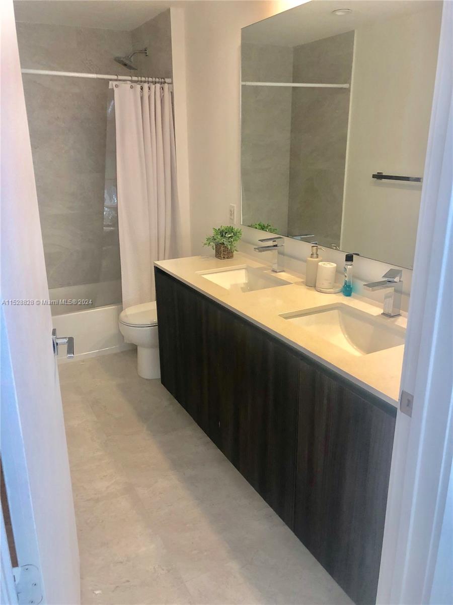 Edgewater Miami, FL 33132 - Photo 6 of 34 a bathroom with a granite countertop sink toilet and shower