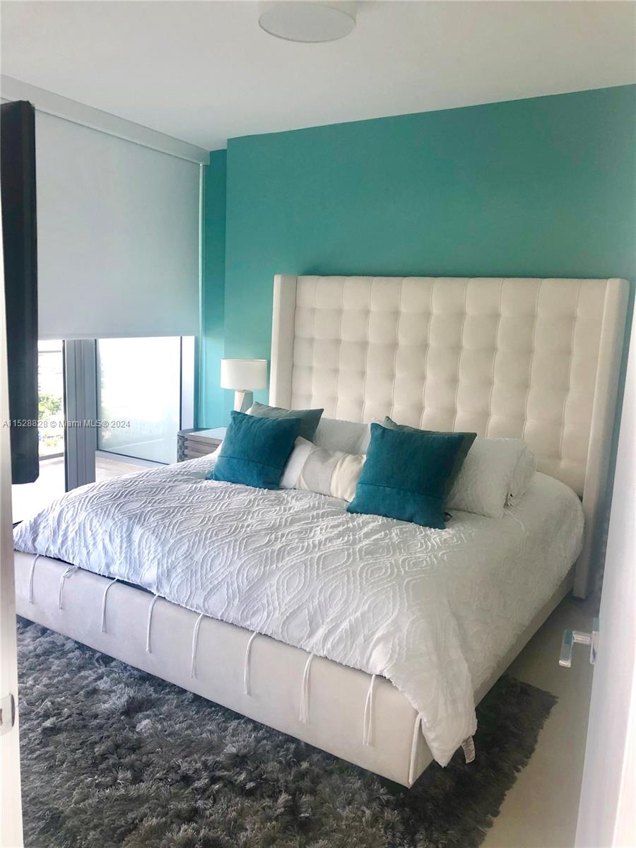Edgewater Miami, FL 33132 - Photo 7 of 34 a large bed sitting in a bedroom next to a window