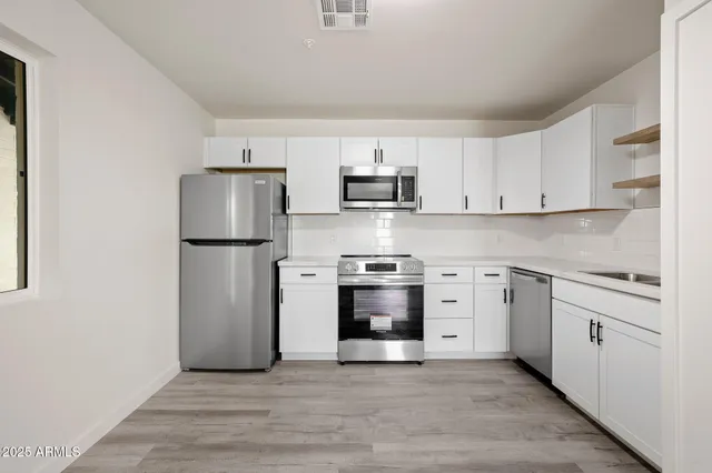 a kitchen with stainless steel appliances a refrigerator sink and microwave