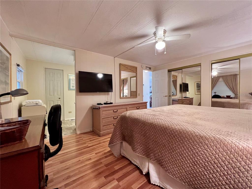 1100 South Belcher Road, Unit 663 Largo, FL 33771 - Photo 25 of 65 a bedroom with a bed and a flat tv screen on dresser