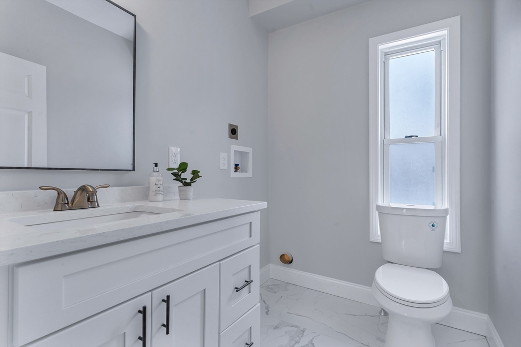 73 Walnut Street Dedham, MA 02026 - Photo 16 of 35 a bathroom with a granite countertop sink toilet and a mirror