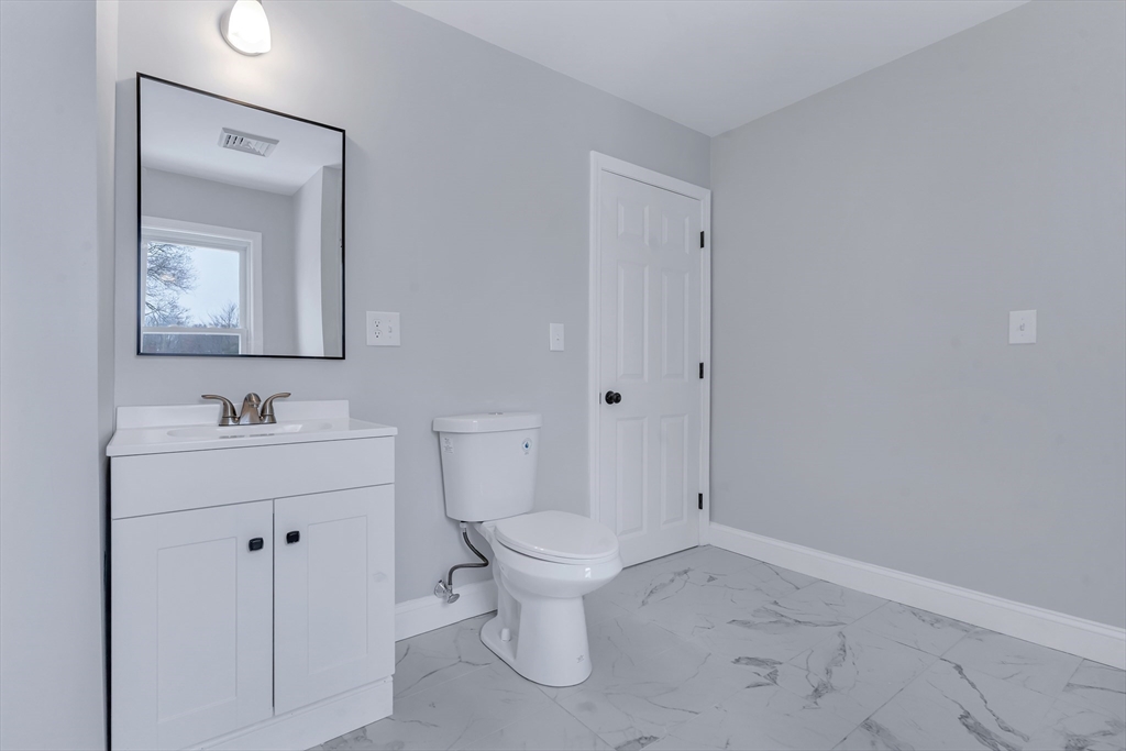 73 Walnut Street Dedham, MA 02026 - Photo 21 of 35 a bathroom with a toilet sink and mirror