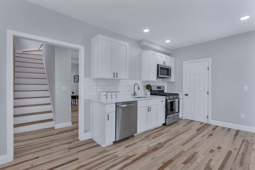 73 Walnut Street Dedham, MA 02026 - Photo 3 of 35 a kitchen with granite countertop white cabinets and stainless steel appliances