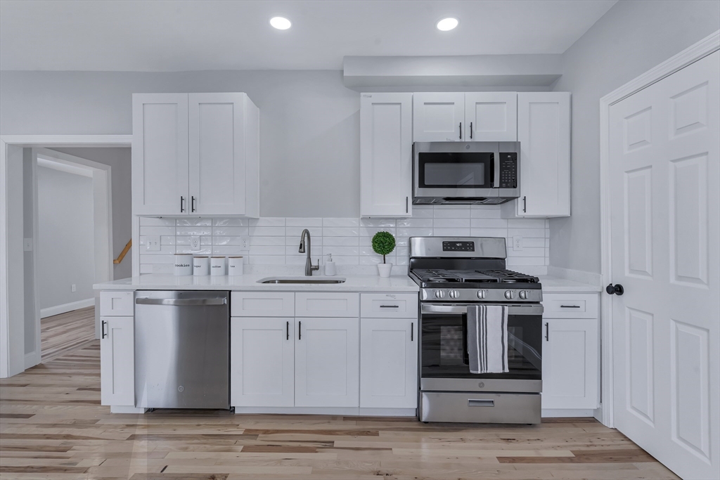 73 Walnut Street Dedham, MA 02026 - Photo 4 of 35 a kitchen with stainless steel appliances granite countertop a stove a sink and a microwave
