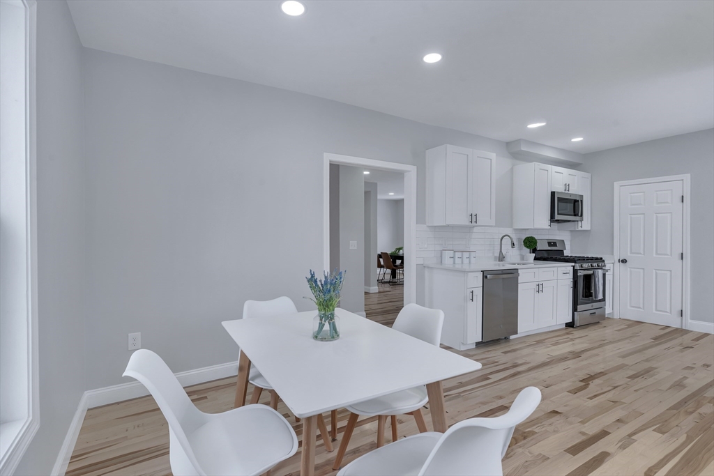 73 Walnut Street Dedham, MA 02026 - Photo 6 of 35 a kitchen with a dining table chairs and refrigerator