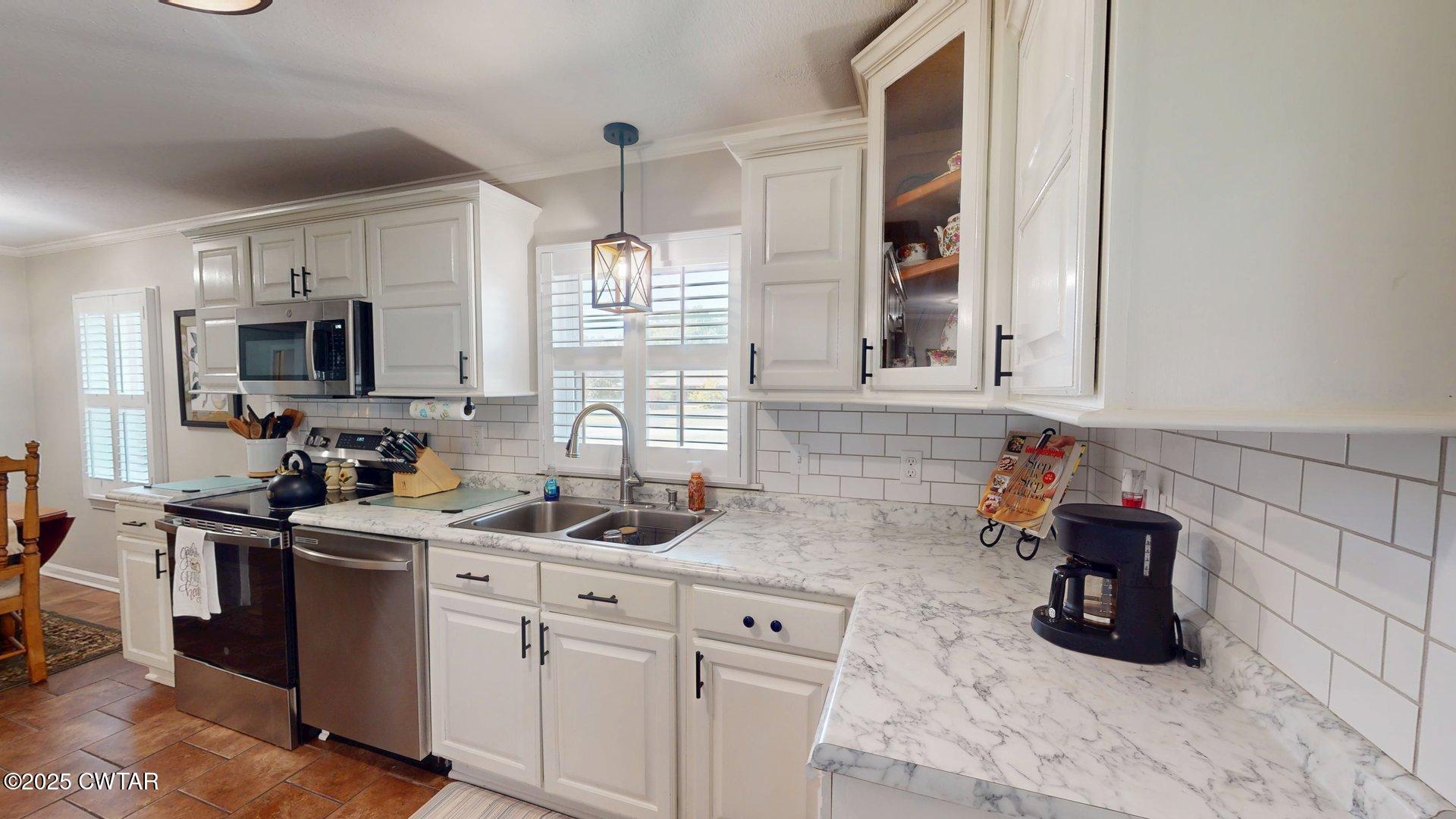 302 Flora Circle Newbern, TN 38059 - Photo 11 of 26 a kitchen with white cabinets and appliances