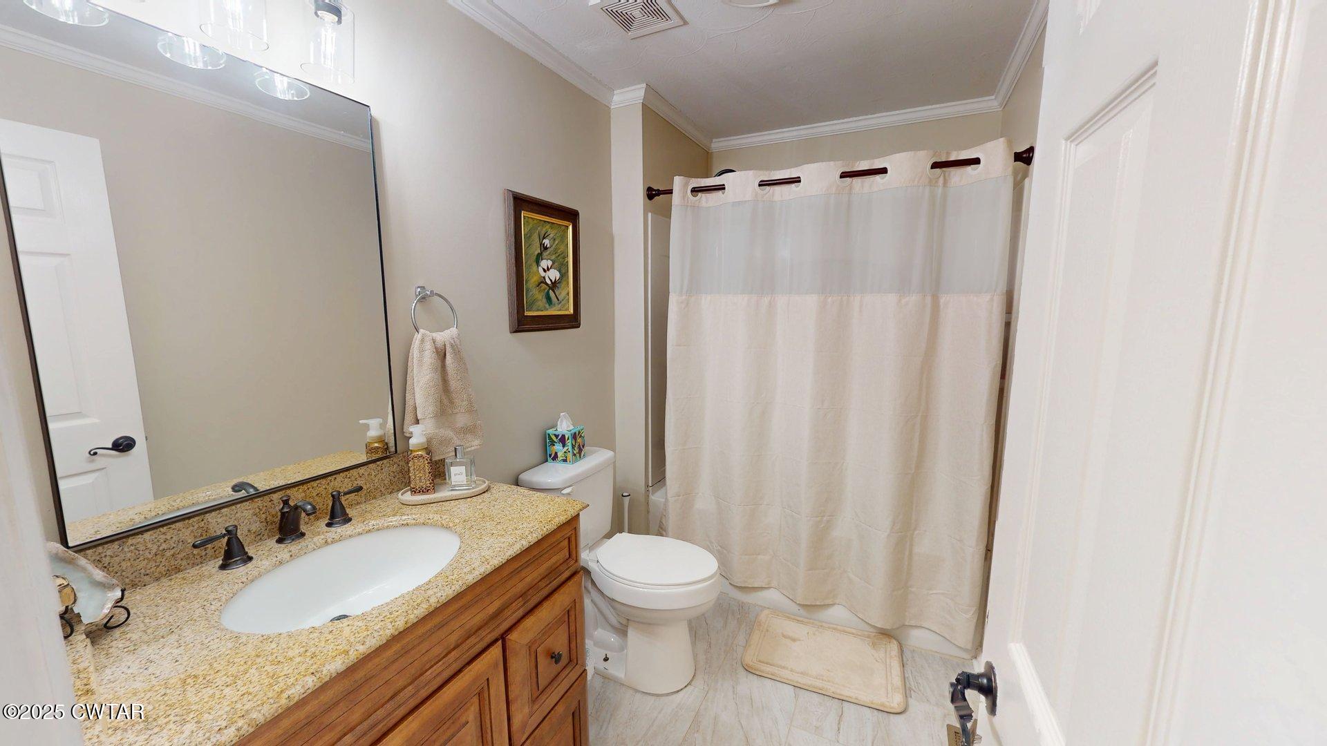 302 Flora Circle Newbern, TN 38059 - Photo 14 of 26 a bathroom with a granite countertop sink toilet a mirror a shower and a tub