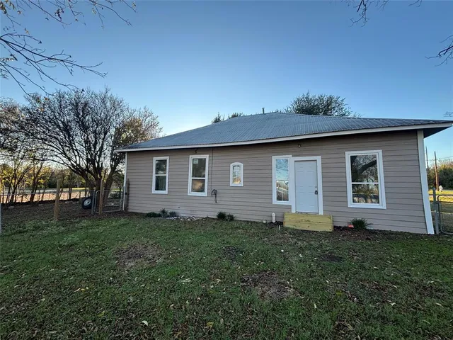 a front view of house with yard and trees