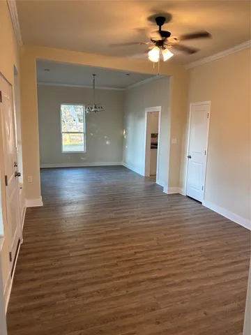 a view of a room with wooden floor and a ceiling fan