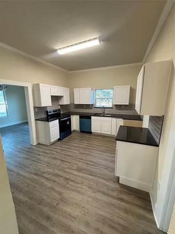 a kitchen with stainless steel appliances kitchen island granite countertop a sink and wooden floor