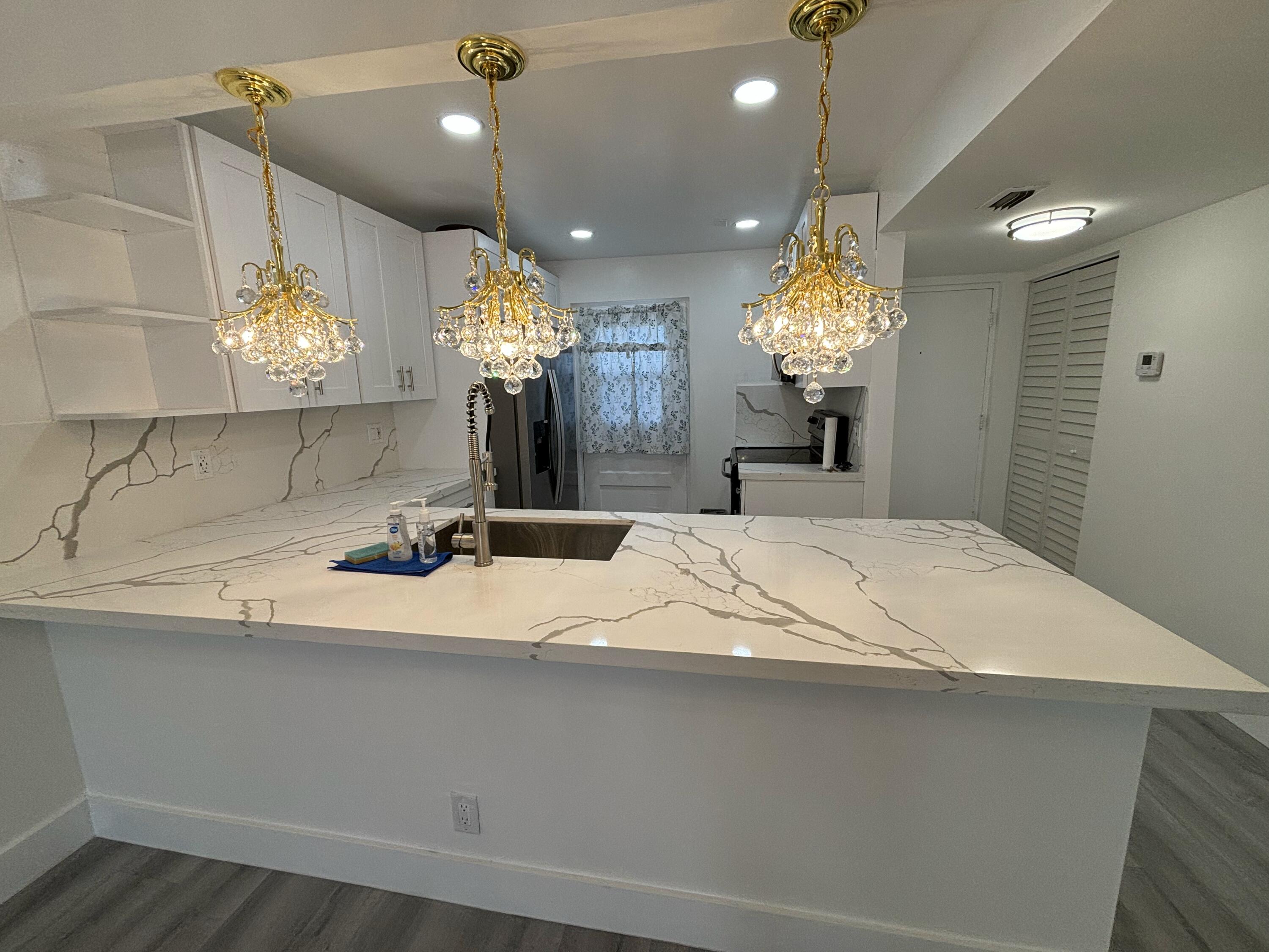 a large bathroom with a sink a large mirror and a chandelier