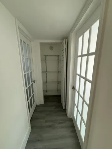 a view of a hallway with wooden floor and stairs