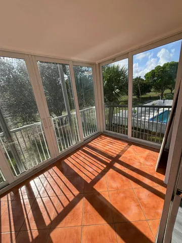 a view of a balcony with floor to ceiling windows with wooden floor