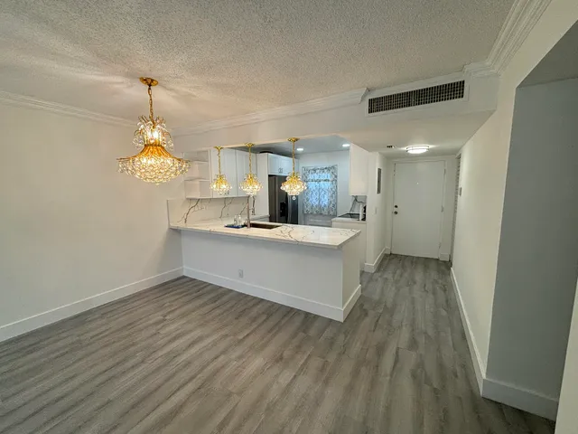 a room with kitchen island a wooden floor and a ceiling fan