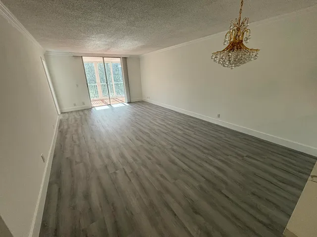 a view of a room with wooden floor and windows