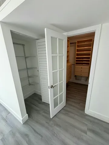 a view of a room with wooden floor and white walls