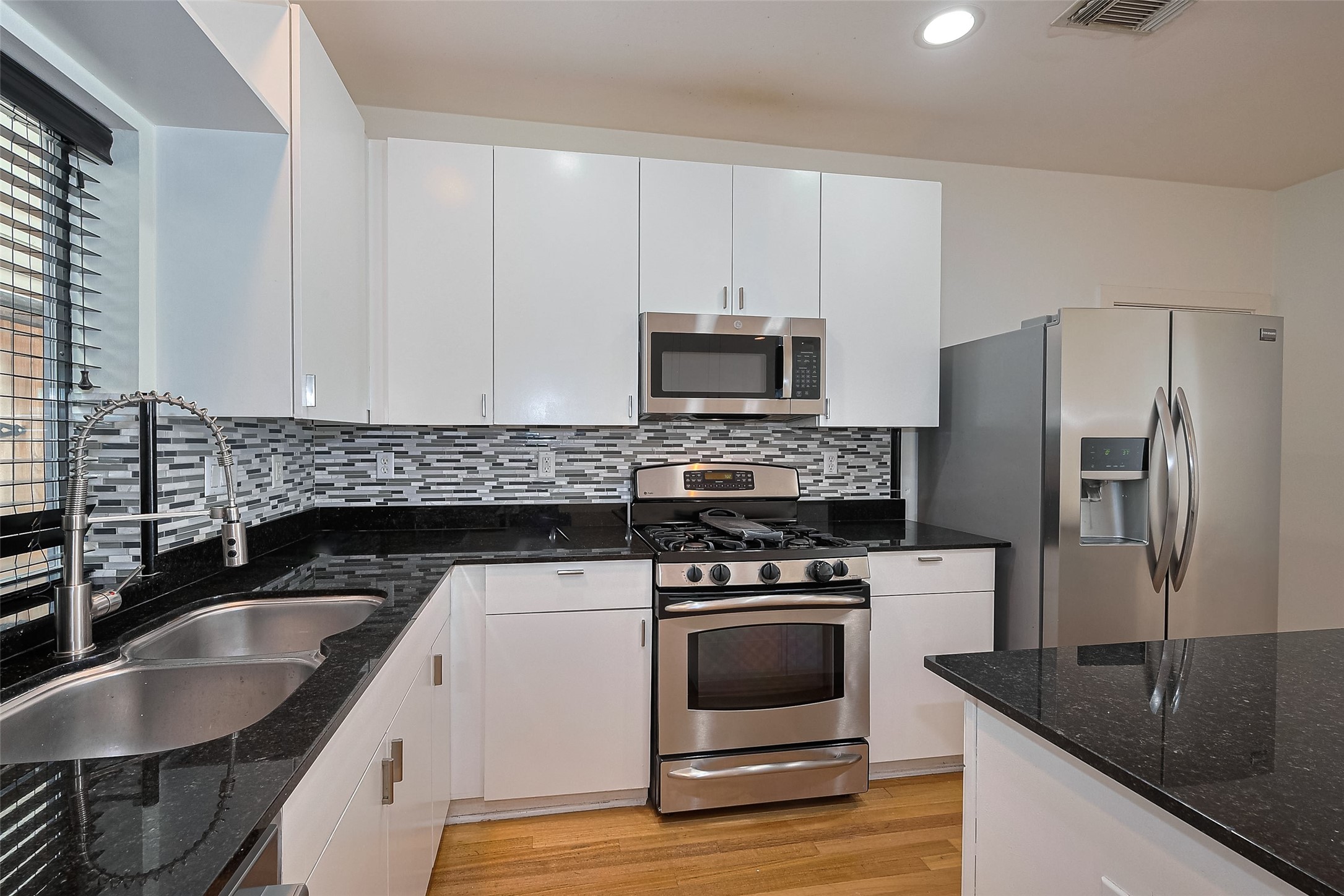 4331 Eigel Street Houston, TX 77007 - Photo 17 of 38 a kitchen with granite countertop a sink a stove and refrigerator