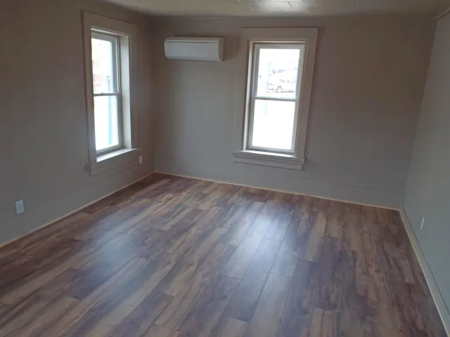 a kitchen with granite countertop a sink cabinets and wooden floor