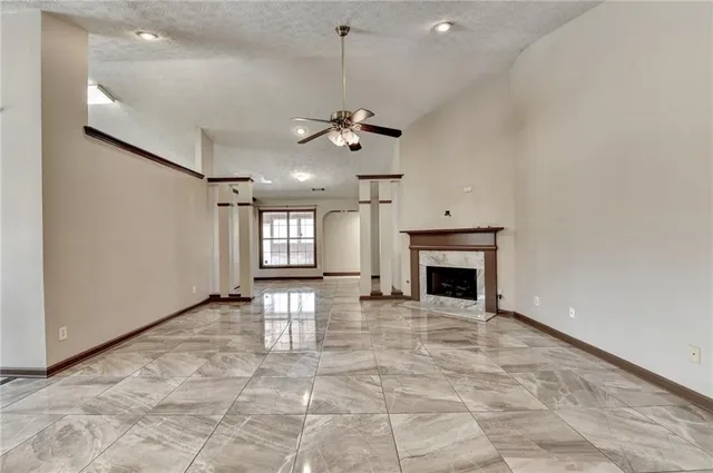 a view of a kitchen with a fireplace a ceiling fan and windows