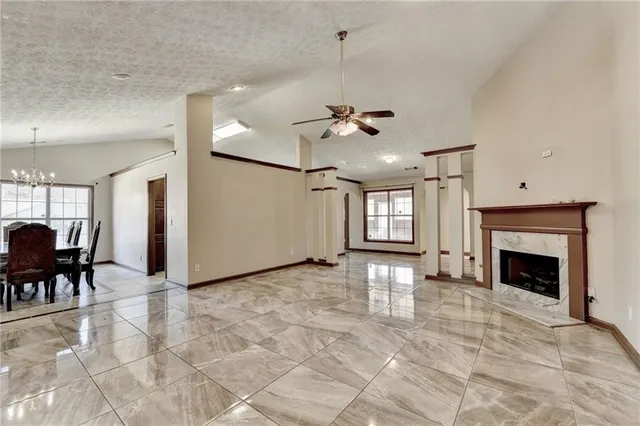 a view of an empty room with window and fireplace