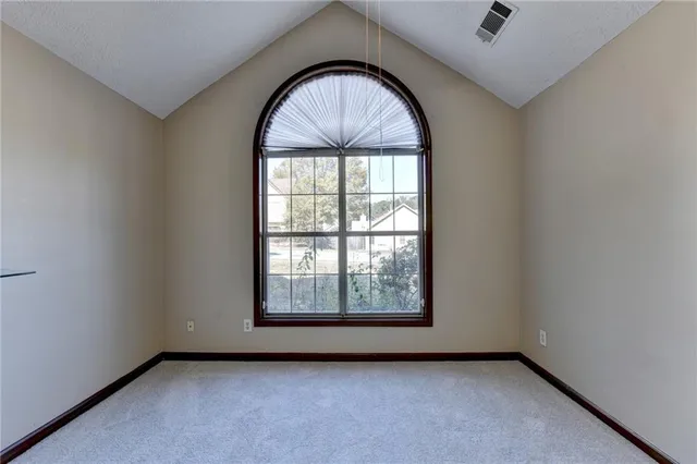 an empty room with chandelier fan