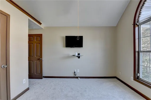 an empty room with a chandelier fan