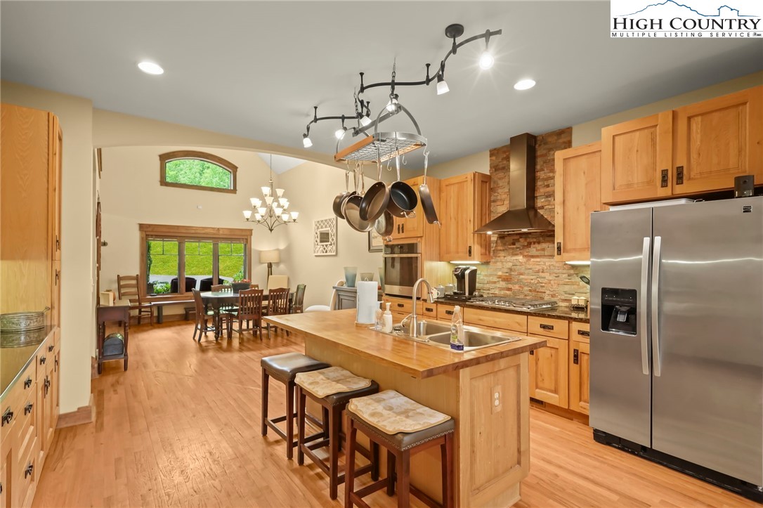 138 South Camp Road, Unit 103 Boone, NC 28607 - Photo 11 of 50 a kitchen with stainless steel appliances granite countertop a refrigerator a sink dishwasher a dining table and chairs with wooden floor