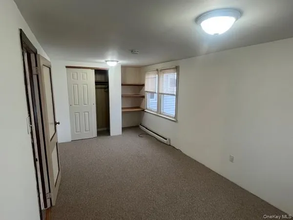 an empty room with closet and windows