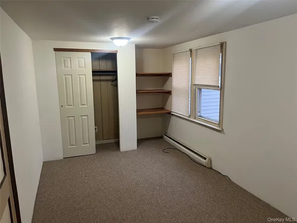 an empty room with closet and windows