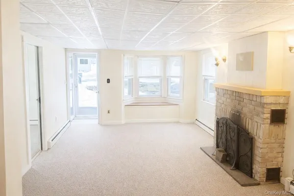 a view of empty room with fireplace and windows