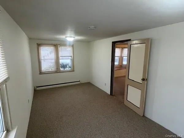 an empty room with windows and closet