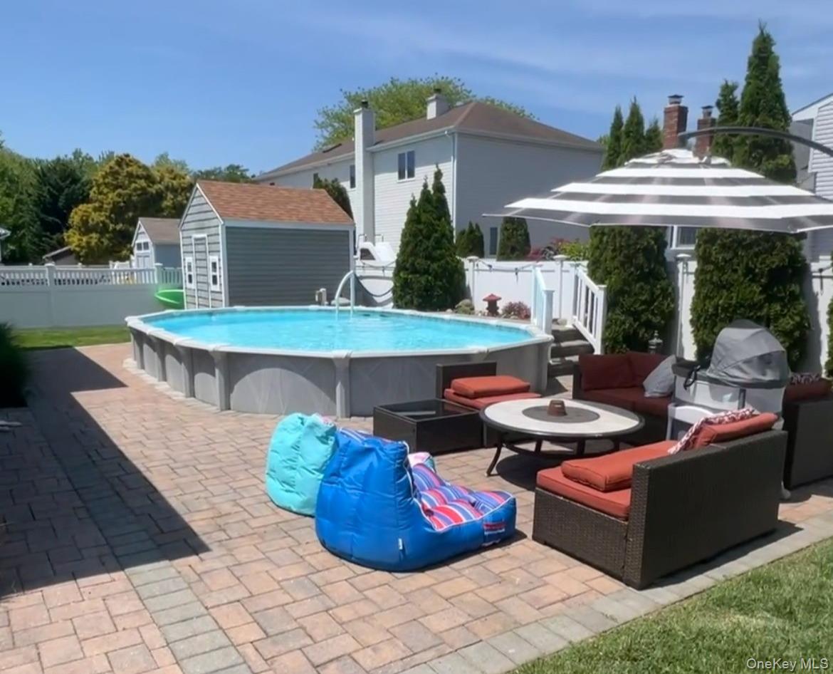 1 Freedom Court Babylon, NY 11702 - Photo 23 of 23 a view of a patio with couches table and chairs under an umbrella