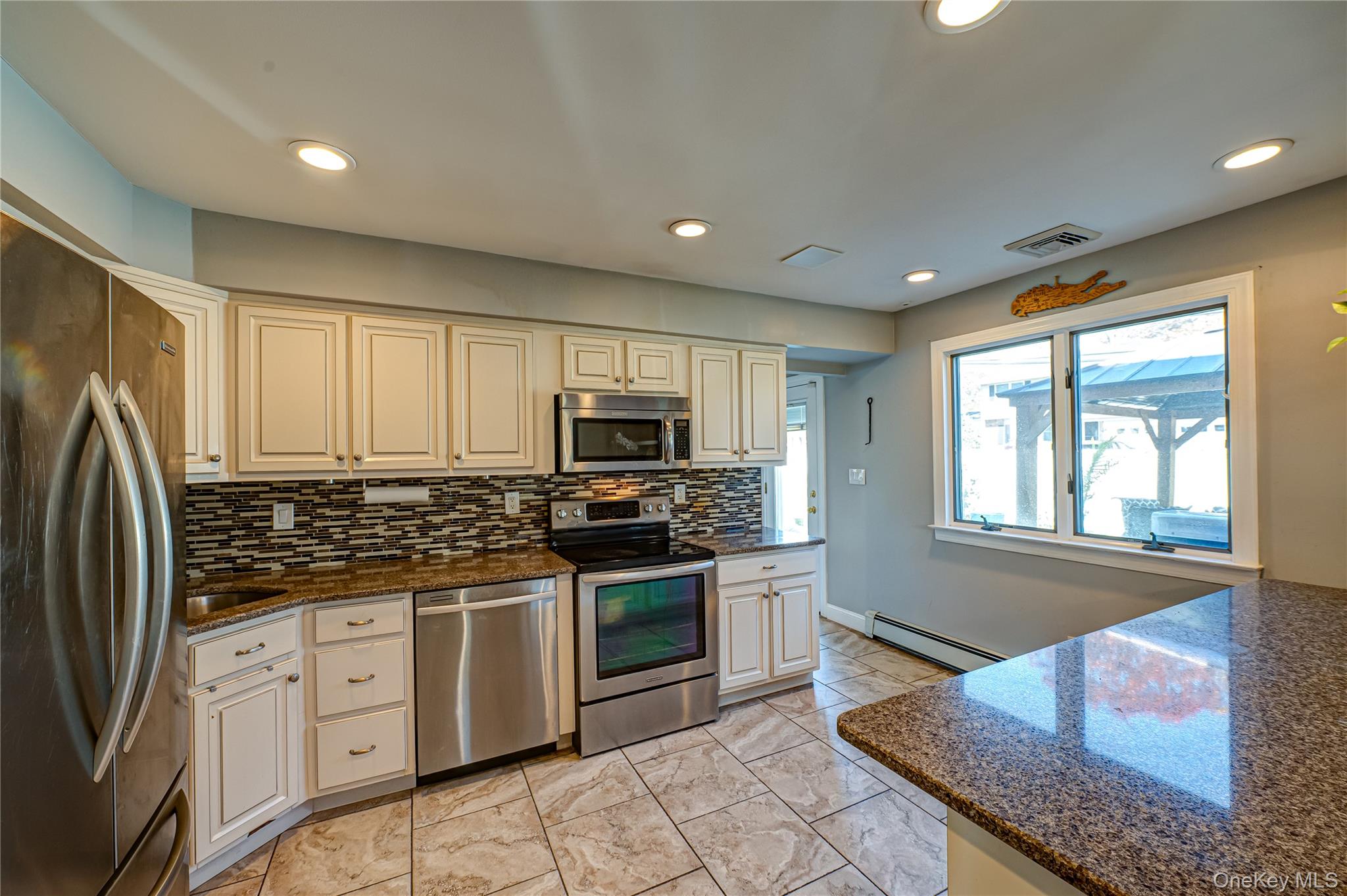 1 Freedom Court Babylon, NY 11702 - Photo 6 of 23 a kitchen with stainless steel appliances granite countertop a stove a sink and a refrigerator