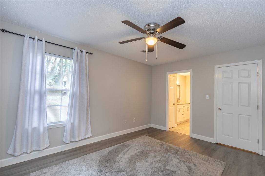 2509 Rolling Green Road Anderson, SC 29621 - Photo 12 of 28 A well-lit bedroom with a ceiling fan, durable flooring, and access to an adjacent bathroom.