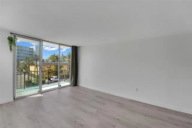 a view of a room with wooden floor and floor to ceiling window