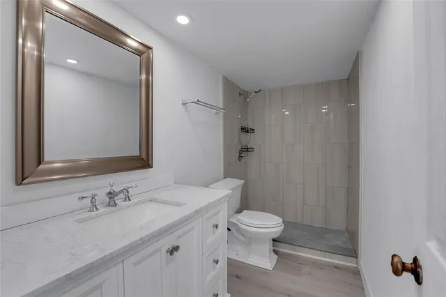 a bathroom with a sink a toilet and shower