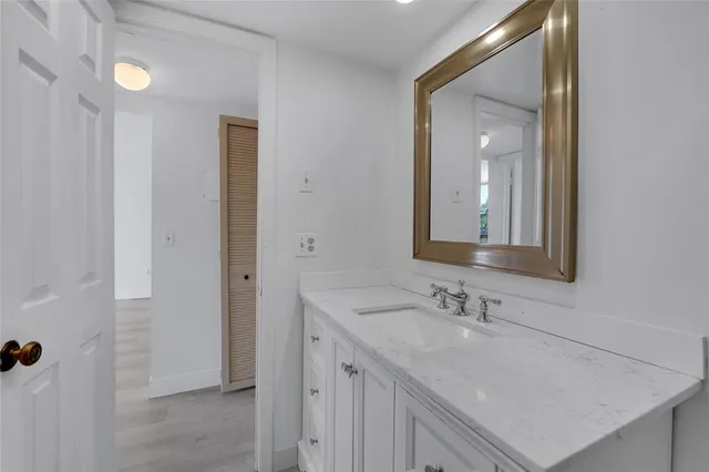 a bathroom with a sink vanity granite and a mirror
