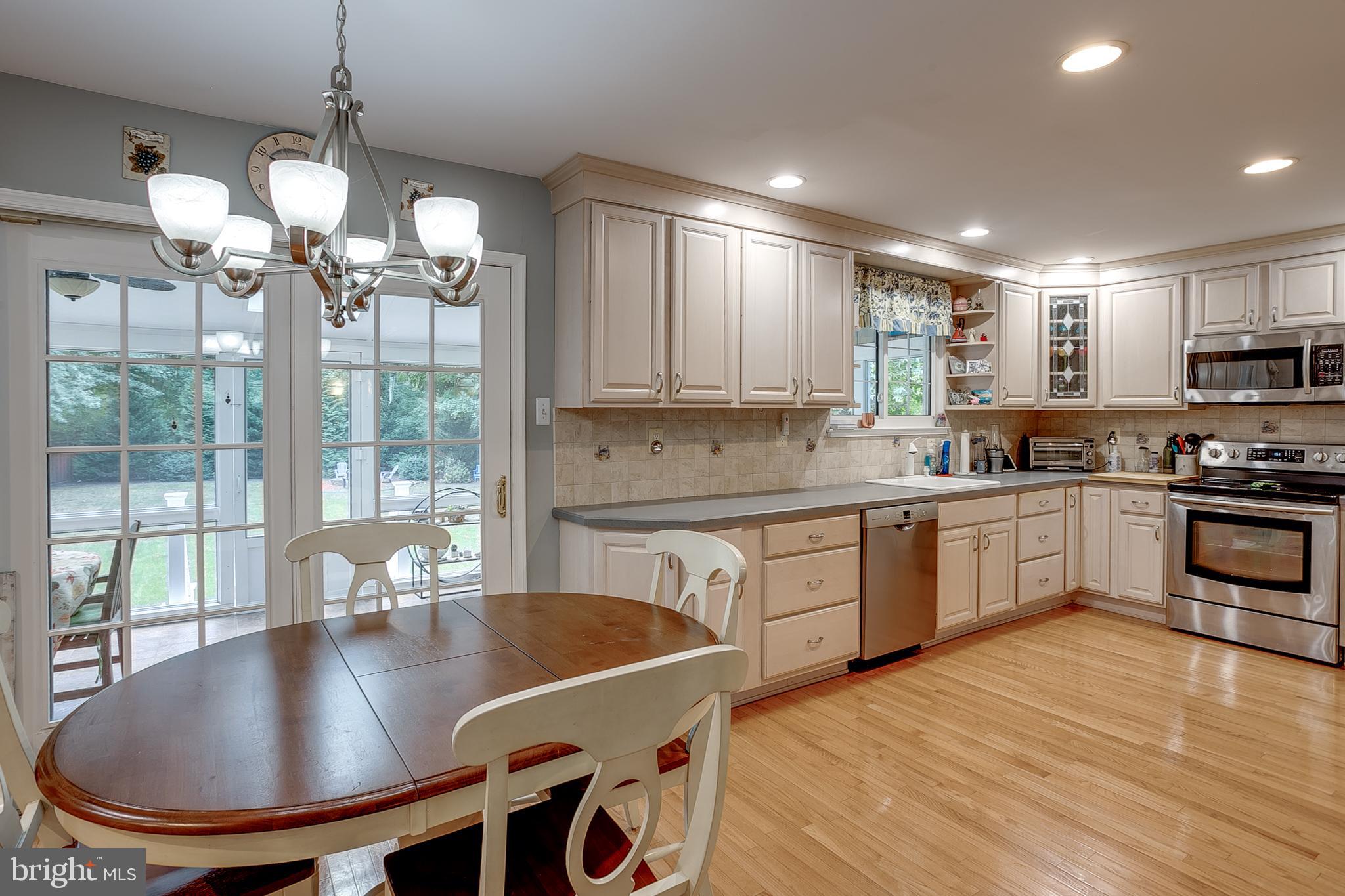 233 Hamilton Road Marlton, NJ 08053 - Photo 20 of 48 a kitchen with stainless steel appliances granite countertop a stove a sink a refrigerator a stove a dining table and chairs with wooden floor