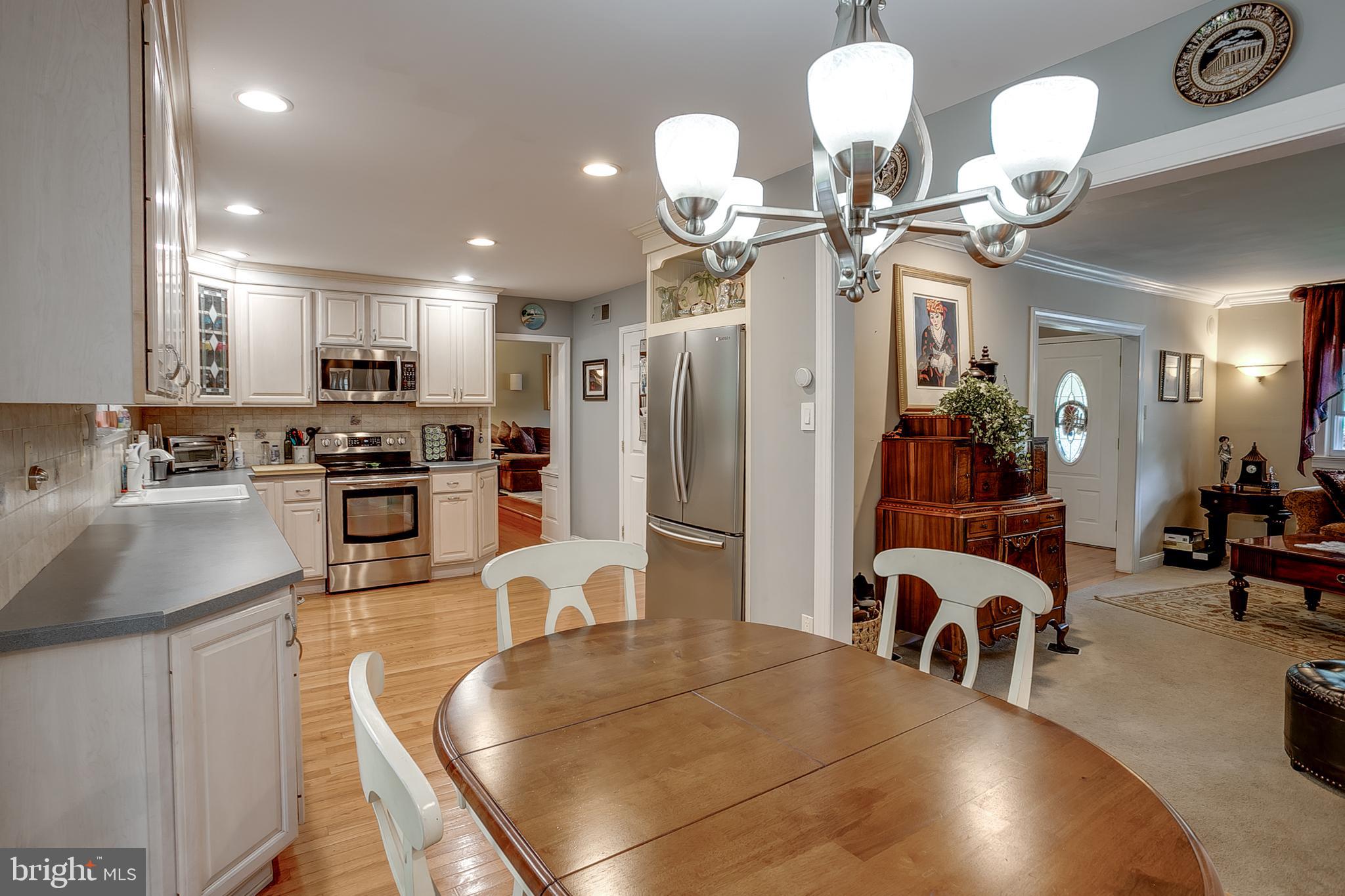 233 Hamilton Road Marlton, NJ 08053 - Photo 32 of 48 a kitchen with stainless steel appliances granite countertop a stove refrigerator a dining table and chairs with wooden floor
