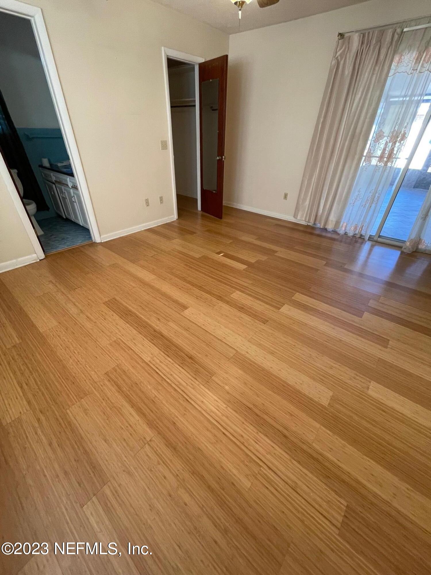 1042 Jamaica Road East Jacksonville, FL 32216 - Photo 13 of 59 a view of an empty room with wooden floor and a window