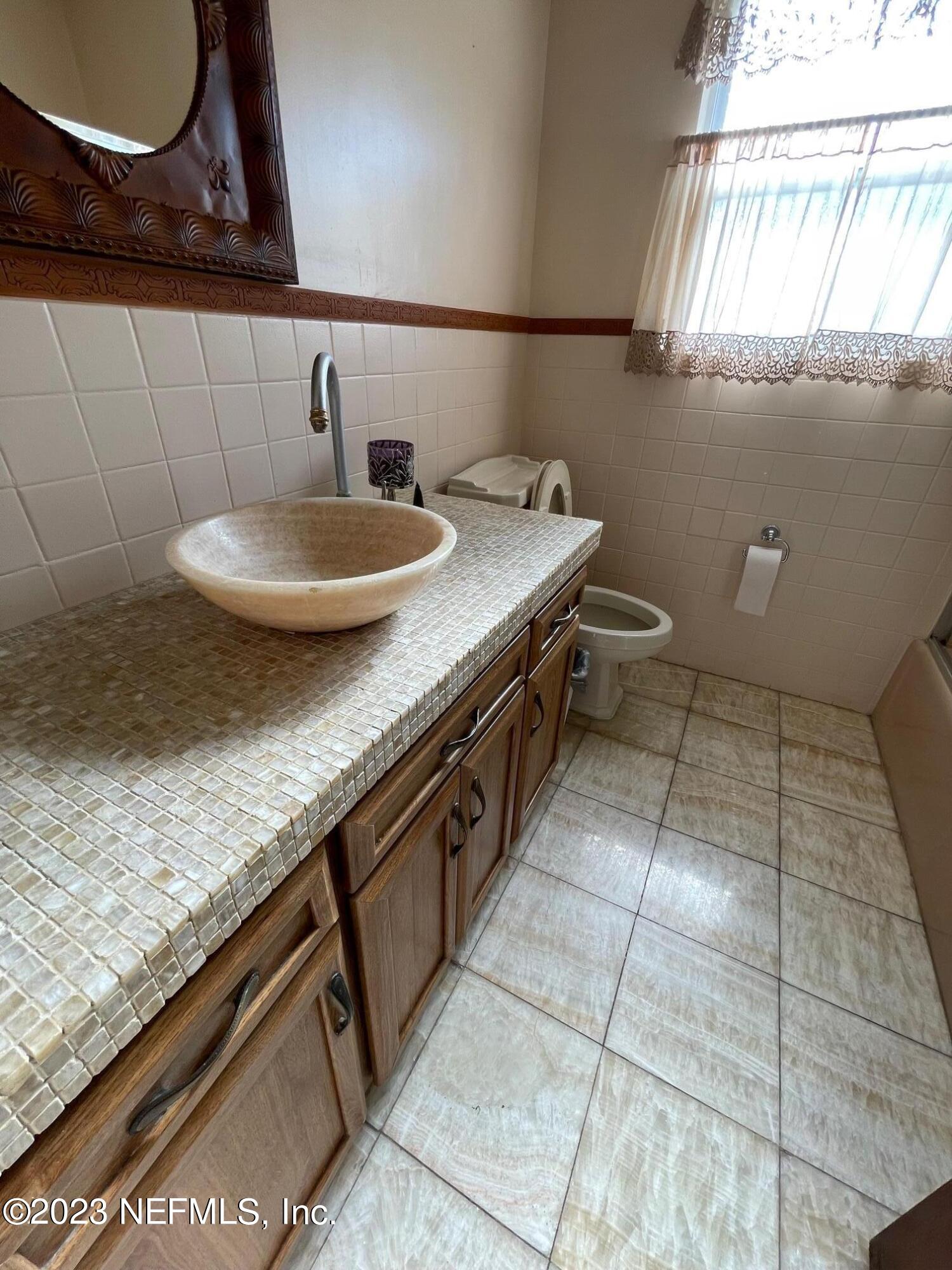 1042 Jamaica Road East Jacksonville, FL 32216 - Photo 24 of 59 a bathroom with a granite countertop sink and a mirror
