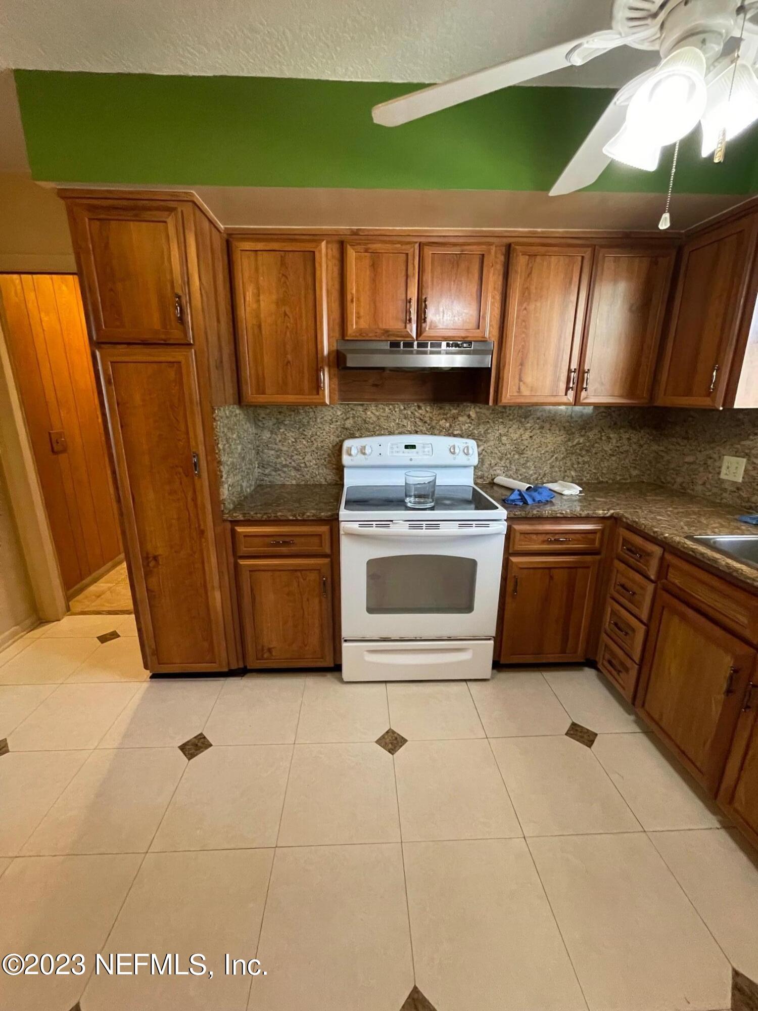 1042 Jamaica Road East Jacksonville, FL 32216 - Photo 31 of 59 a kitchen with stainless steel appliances granite countertop a stove a sink and a microwave