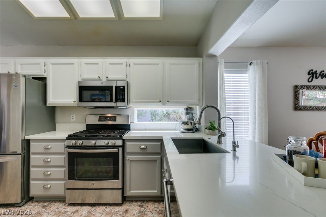 2187 Chapman Ranch Drive Henderson, NV 89012 - Photo 10 of 26 This modern kitchen features sleek white cabinetry and state-of-the-art stainless steel appliances.