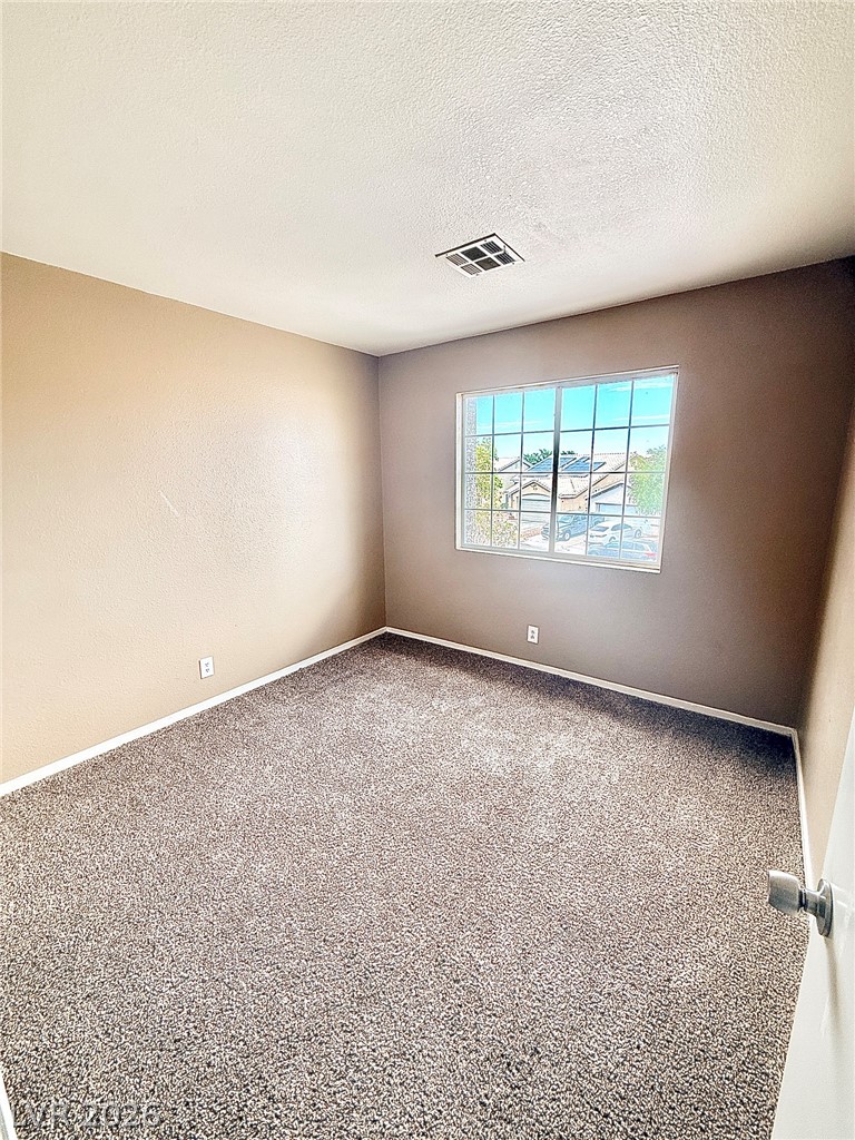 4313 Ranch Foreman Road North Las Vegas, NV 89032 - Photo 15 of 27 Plush carpeting anchors this inviting bedroom illuminated by a multi-pane window.