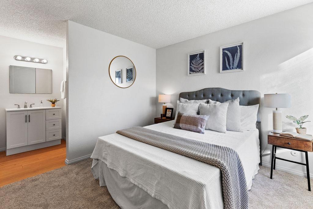 5918 Rancho Mission Road, Unit 62 San Diego, CA 92108 - Photo 19 of 37 a bedroom with a bed and a lamp on dresser
