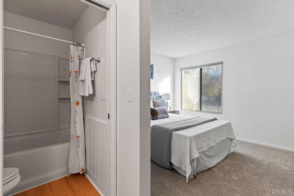 5918 Rancho Mission Road, Unit 62 San Diego, CA 92108 - Photo 23 of 37 a bathroom with a tub sink shower and a mirror
