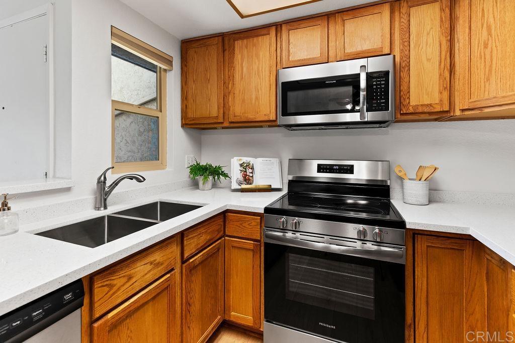 5918 Rancho Mission Road, Unit 62 San Diego, CA 92108 - Photo 5 of 37 a kitchen with stainless steel appliances granite countertop a sink stove and microwave