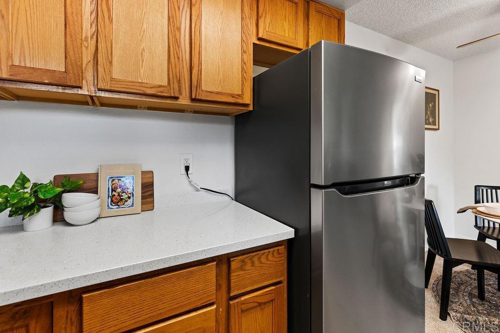 5918 Rancho Mission Road, Unit 62 San Diego, CA 92108 - Photo 6 of 37 a kitchen with stainless steel appliances granite countertop a refrigerator and a sink