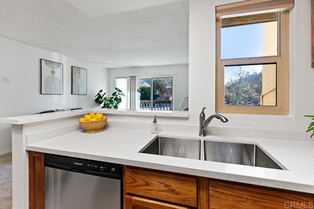 5918 Rancho Mission Road, Unit 62 San Diego, CA 92108 - Photo 7 of 37 a view of a kitchen island a sink wooden floor and a window