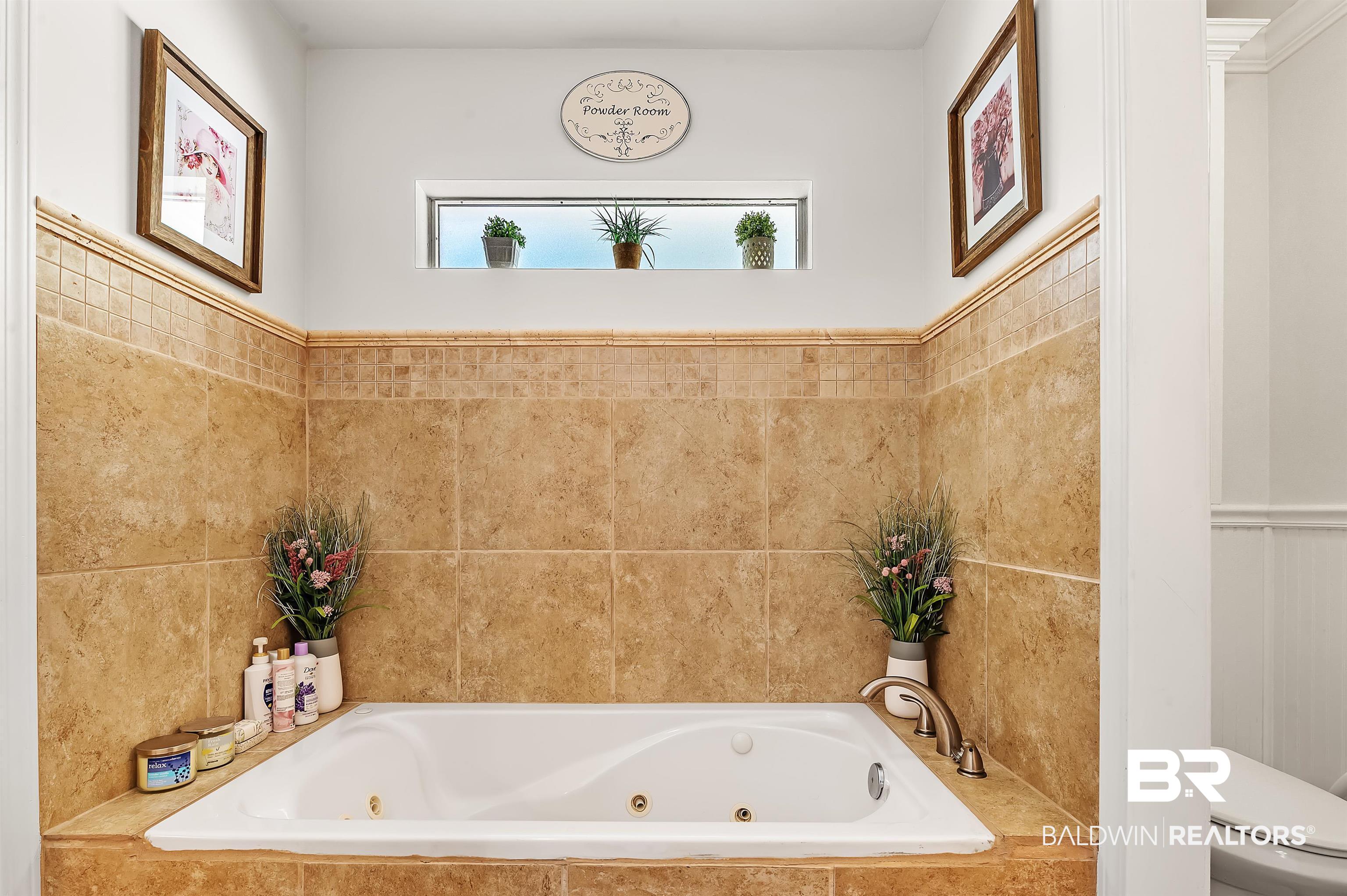 9901 Glover Court Fairhope, AL 36532 - Photo 23 of 52 Bathroom featuring tiled bath, tile walls, and toilet
